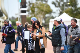 Fans check in using a QR-code at an AFL game.