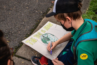 A student prepares a sign for the Friday protest. 