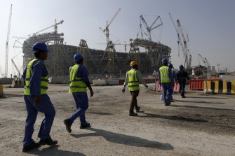 Workers walk to the Lusail Stadium, one of the venues for the World Cup in Qatar later this year.