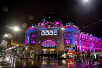 Flinders Street Station is lit up during curfew this week.