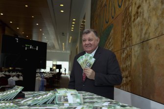 Craig Kelly with fake trillion dollar notes to “commemorate Australia’s Net Government Debt” on budget day at Parliament House in Canberra.