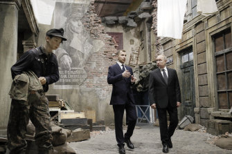 Russian President Vladimir Putin, right, walks through a scene depicting a Berlin street after capitulation in 1945 during a visit to a St Petersburg exhibition in 2020. 