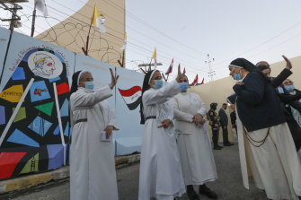 Iraqi nuns wave as Pope Francis leaves the Sayidat al-Nejat (Our Lady of Salvation) Cathedral, in Baghdad. 