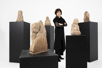 Worn, humble and powerful: Powerhouse curator, Min-Jung Kim with some of the stone Arhats statues from South Korea.