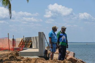 Pabai Pabai and Paul Kabai looking at the sea next to the seawall in Boigu. 