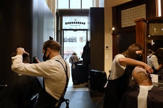 Senior barber Jennifer Oliver, second from right, at Barberhood in Martin Place. 
