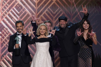 The cast of CODA accepts the award for outstanding performance by a cast in a motion picture and signs “I love you” at the SAG Awards.