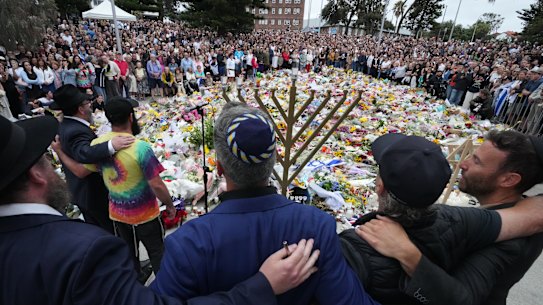 Mourners gather at Bondi Pavilion’s floral memorial at for victims of the massacre on Sunday.