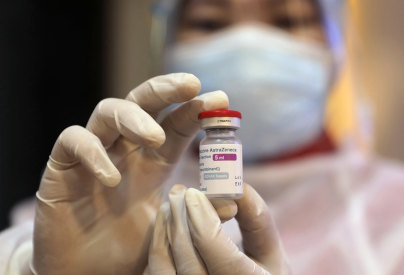 A health worker shows a vial of the AstraZeneca COVID-19 vaccine in Surabaya, East Java.