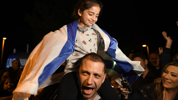 Noya Dahan, 8, rides on the shoulders of her father, Israel Dahan, at a candlelight vigil.