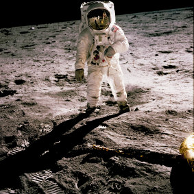 Buzz Aldrin walks on the moon during the first human landing in 1969. Fellow astronaut Neil Armstrong the first to set foot on the moon, is seen reflected in Aldrin’s helmet glass.