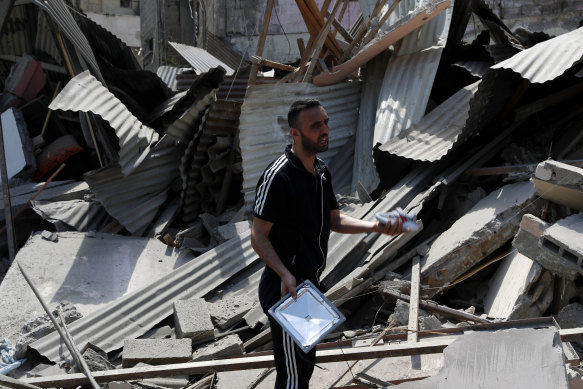 A man holds a child’s shoe as he inspects buildings destroyed by Israeli air strikes in Gaza.