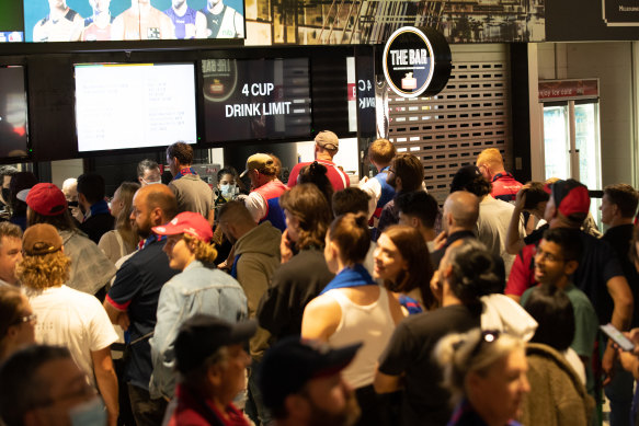 Football fans line up at a bar at the MCG on Wednesday night.