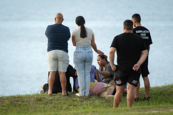 Family members gather after a body was located at Penrith Beach.