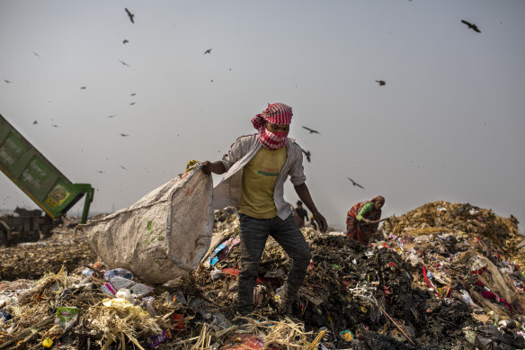Waste workers look for recyclables at Bhalswa landfill on the outskirts of New Delhi, India.