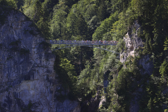 Tourists stand on the Marienbruecke bridge, near the Neuschwanstein castle.