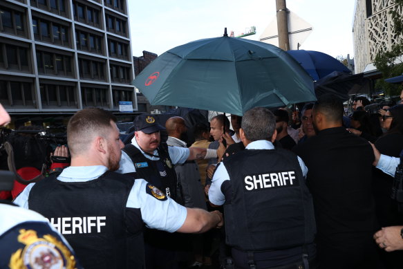 Sheriffs intervene after a scuffle breaks out outside the court.