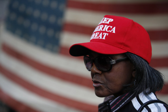 A woman stands in front of an American flag, as a handful of supporters of President Donald Trump protest outside the Pennsylvania Convention Centre, in Philadelphia, earlier this week.