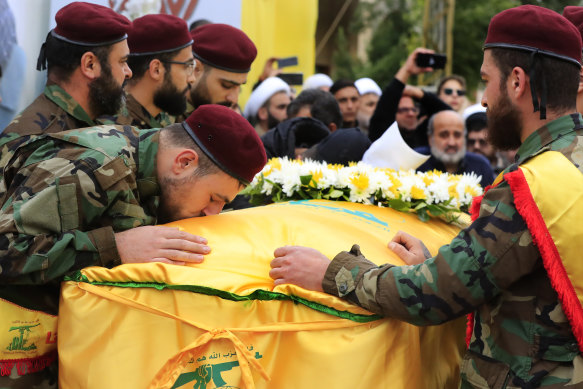 A Hezbollah fighter kisses the coffin of Ali Bazzi, who was killed in the airstrike.