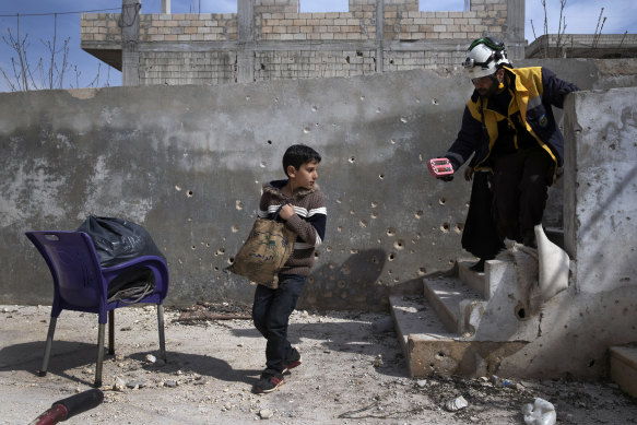 Muhammad Hussein Alloush, 10, collects items from his family home in Balyoun, Syria.