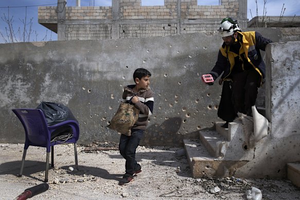 Muhammad Hussein Alloush, 10, collects items from his family home in Balyoun, Syria.