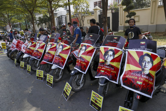 Soccer fans of Arsenal Football Club display placards against the military coup in their motorbikes in Mandalay, Myanmar.