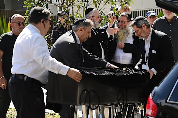 The casket of Rabbi Eli Schlanger arrives for the funeral service.