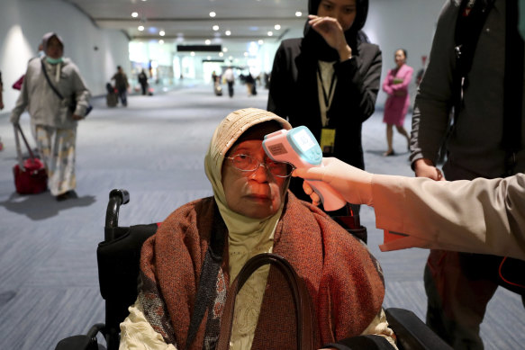 Temperature checks are used to monitor incoming passengers in Indonesia.