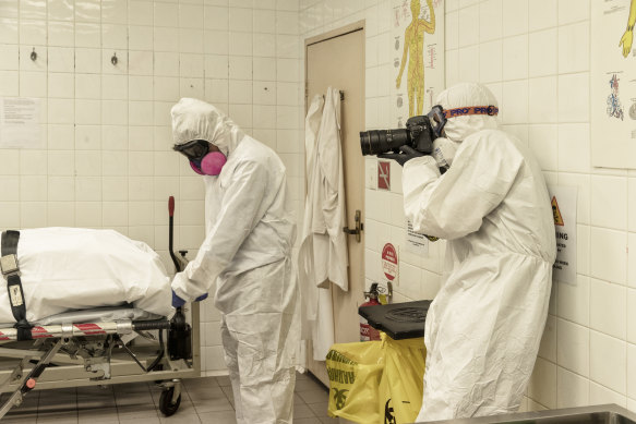 Herald photographer James Brickwood is dressed in full PPE gear to document operations in a Sydney morgue.