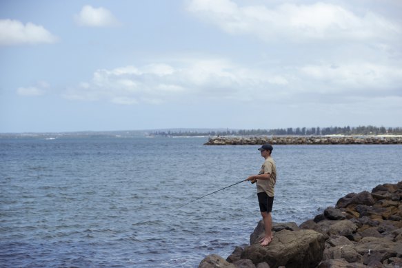 A fisherman at Tower Beach this week. Signs banning fishing were not visible from where he was standing at the southern end of the beach. 