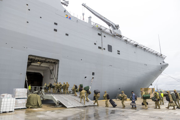 Soldiers entering the HMAS Adelaide at the Port of Brisbane on Thursday last week, before departing for Tonga. 