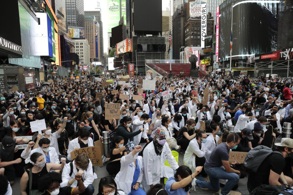 Hospital workers kneel in Times Square in New York City during a protest against police brutality.
