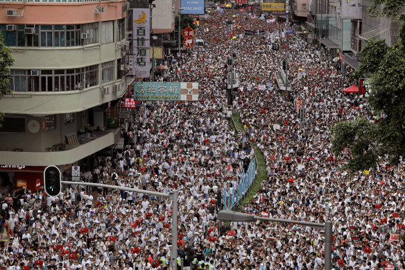 Protesters march along a downtown street against the proposed amendments to an extradition law in Hong Kong.