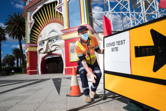 A sign outside Luna Park points to a pop-up testing site in the Palais car park in St Kilda. 