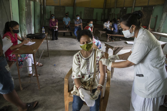 An Indian woman is injected with a dose of COVAXIN as she gets vaccinated against the coronavirus in Assam, India on Monday.