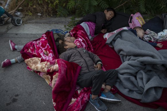 Migrants sleep on the road in Lesbos, Greece, after the Moria refugee camp was destroyed by fire.
