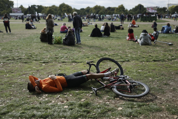 A cyclist takes a nap after watching the State Funeral Service of Britain’s Queen Elizabeth II on giant screens, in London.