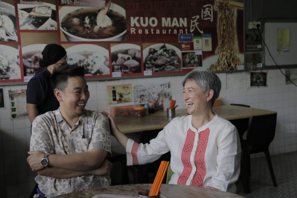 Penny Wong with her brother James, eating fishball congee on Thursday in Kota Kinabalu.
