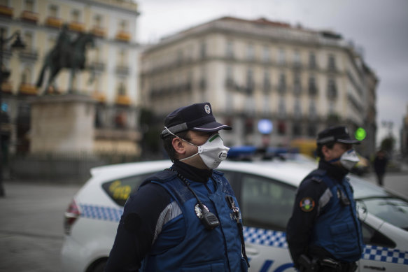 Police officers wearing face masks hold a minute of silence for the victims of COVID-19 as the lockdown to combat the spread of coronavirus continues at the Sol square in Madrid, Spain.