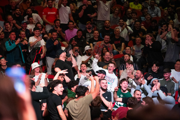 A man is cheered at Qudos Bank Arena as he drinks from a shoe, a well-known celebration of local fan favourite, Tai Tuivasa.