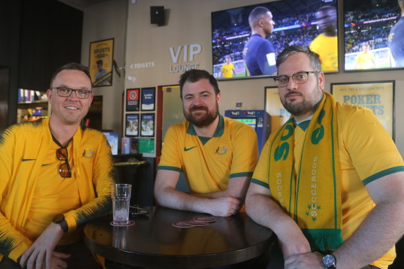 Socceroos fans Aaron Weakley (left), Daniel Carr (middle) and Brendan Elliott (right) reflect on the short period of glory in the first half.