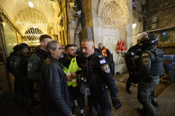 Israeli police hold a suspect, centre, as they raid the al-Aqsa mosque in Jerusalem on Wednesday.