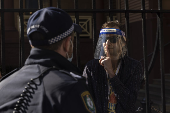 A protestor gestures towards a police officer outside NSW Parliament House on Tuesday.