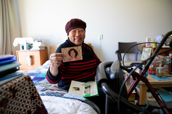 Jani Suganda in her room at the facility, with a photo of her younger self. 