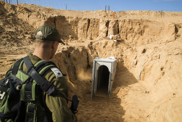 An Israeli soldier stands on the Israeli side of the border with Gaza, near the opening of a tunnel, that Israel says was dug by the Islamic Jihad militant group, leading from Gaza into Israel.