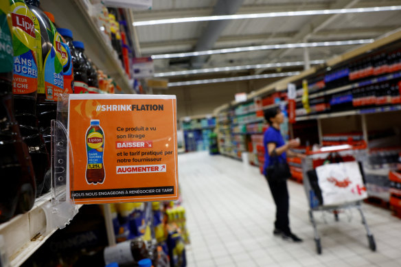 A Carrefour near Paris displays a sign that reads “Shrikflation: This product has seen its quantity decrease and the price charged by our supplier increase. We aim to renegotiate this price.”