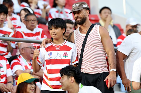 Quade Cooper poses for a photograph with a fan in Osaka.