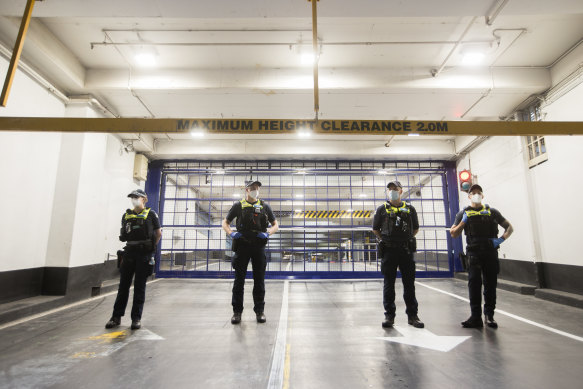 Victorian police officers guarding the entrance to the law firm’s carpark this evening.