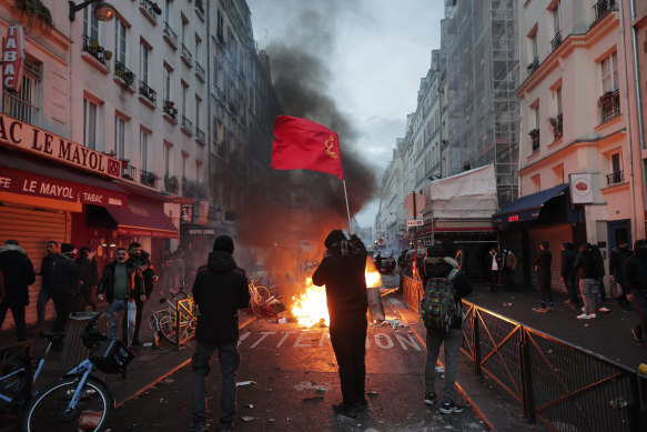 A members of Kurdish community waves the Kurdish communist flags next to a barricade on fire at the crime scene where the shooting took place in Paris.