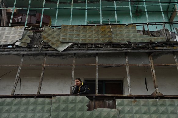 A young Ukrainian woman on the balcony of her apartment building, which was damaged by Russian missile attacks on Kramatorsk.